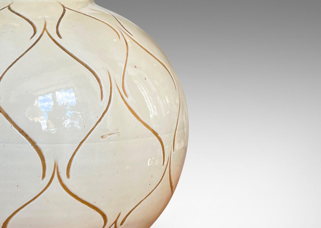 Gallery BAC globe form with wide neck glazed in a gloss ivory and decorated with a sgraffito ogival/leaf pattern