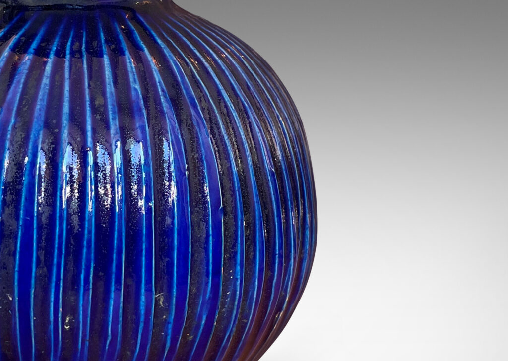 Gallery BAC plump pumpkin form with carved vertical ribs and wide neck, glazed in a gloss saturated deep blue