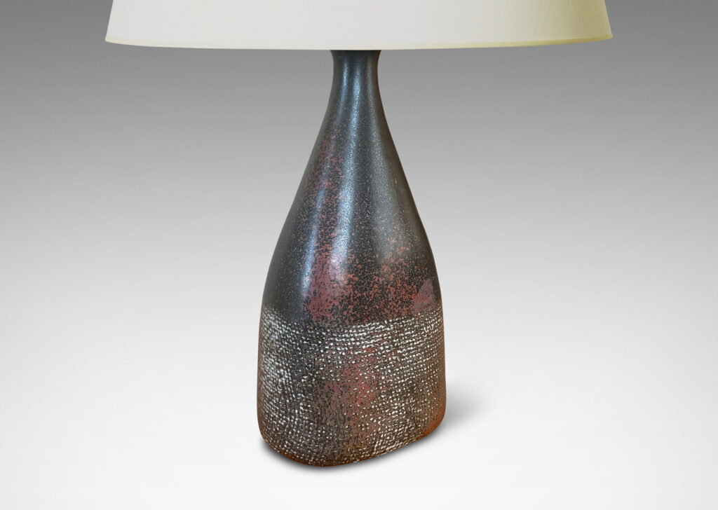Gallery BAC bottle-like form with conical neck and textured body, glazed in black with red luster and pale gray aspects