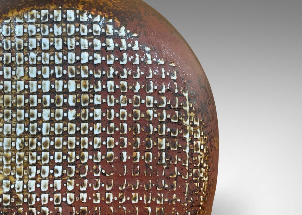 Gallery BAC bottle like form with a textured dome body and sprouting neck, glazed in a dappled oxblood