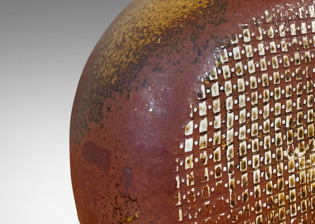 Gallery BAC bottle like form with a textured dome body and sprouting neck, glazed in a dappled oxblood
