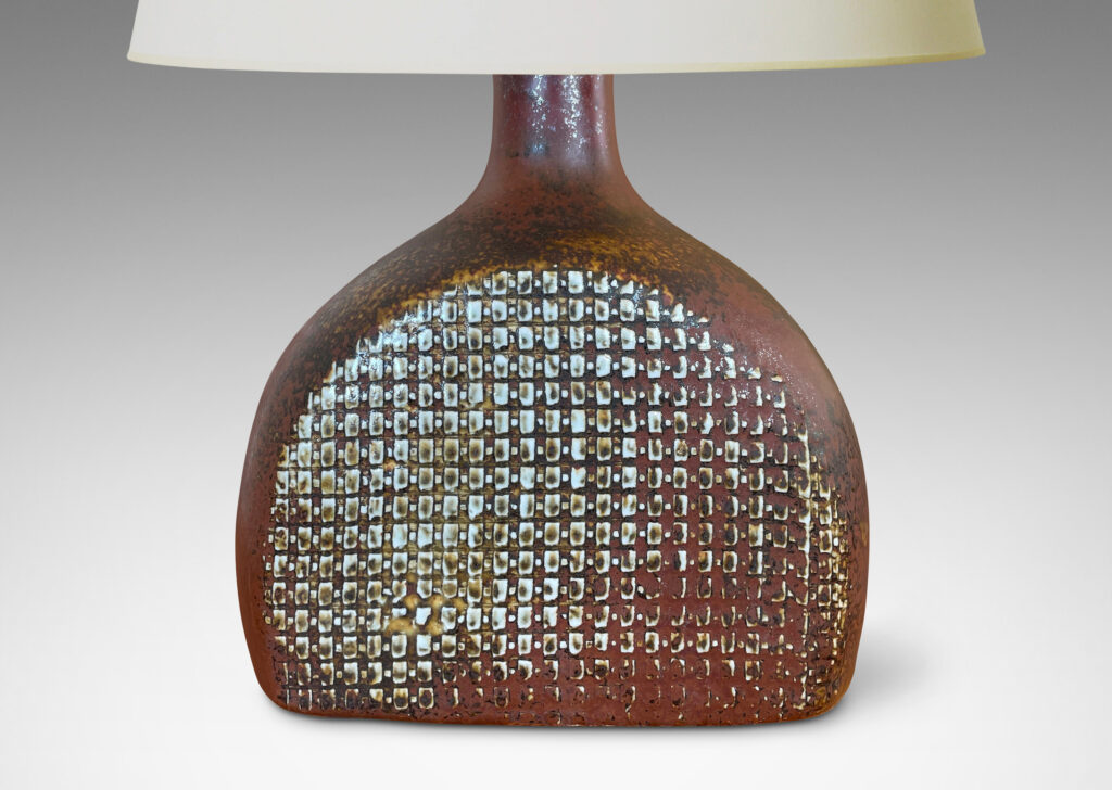 Gallery BAC bottle like form with a textured dome body and sprouting neck, glazed in a dappled oxblood