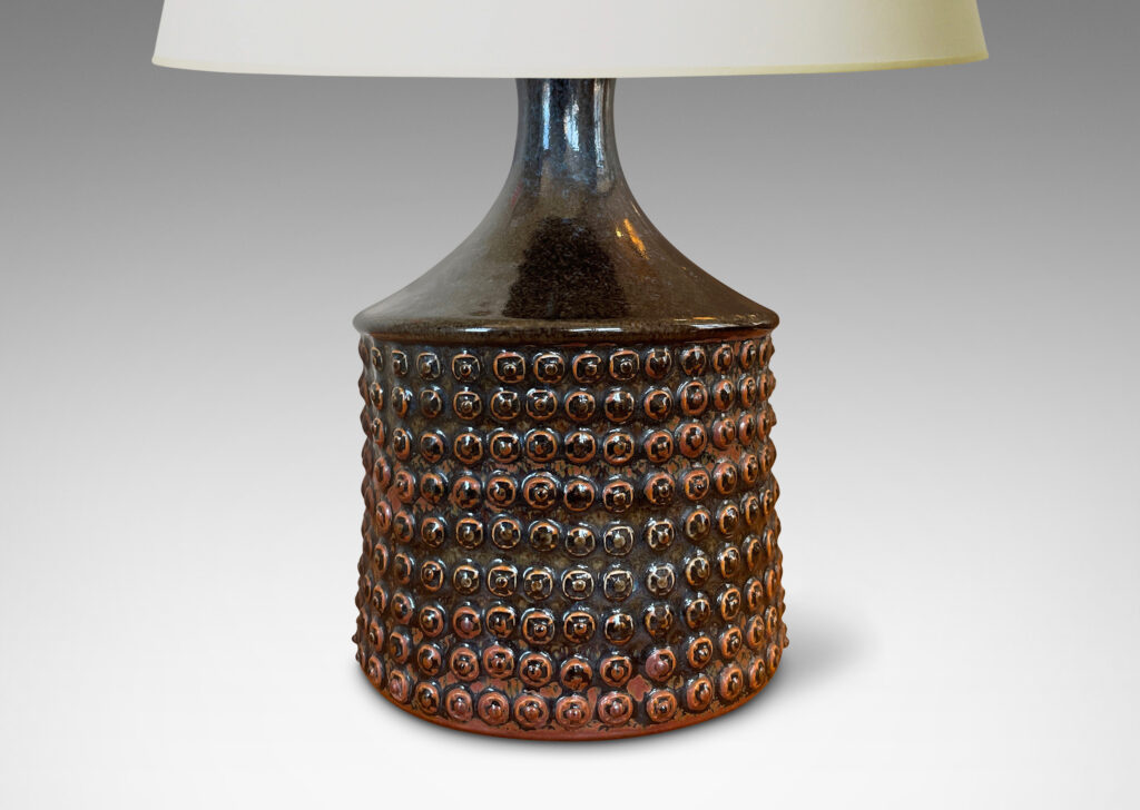 Gallery BAC knobbed drum form with spouting neck, glazed in black with rust accents