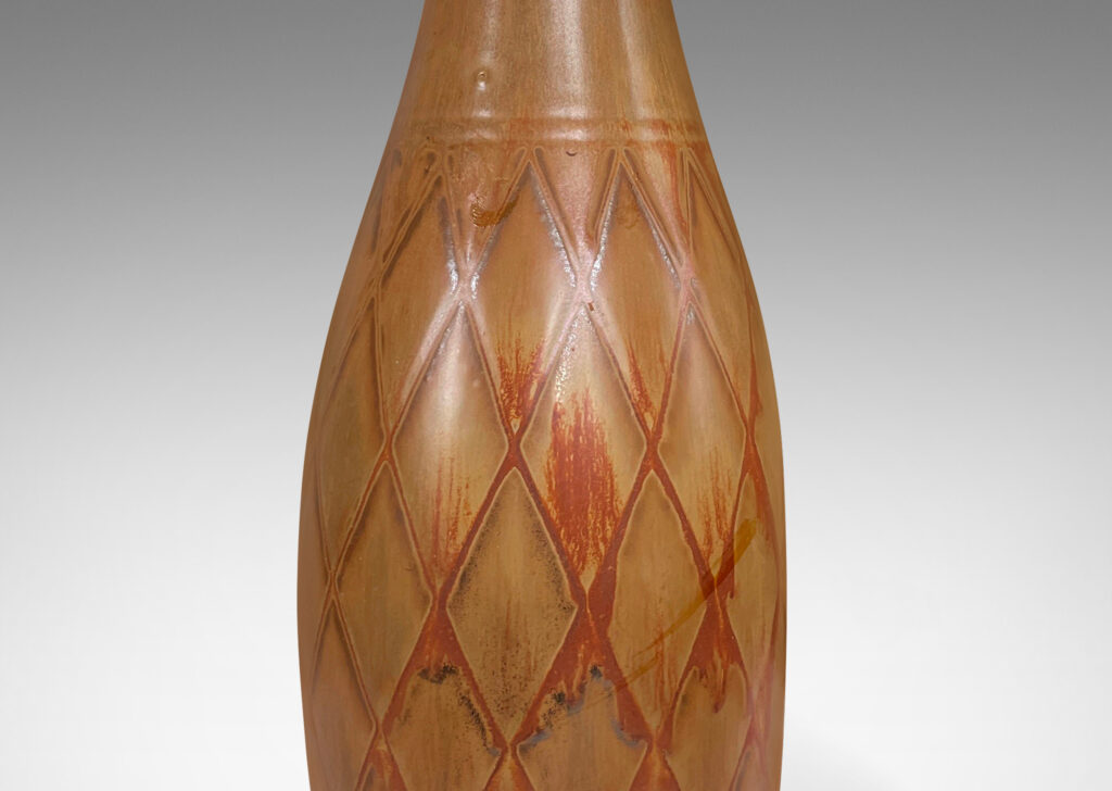 Gallery BAC tall bottle forms with carved diamond pattern, and glazed in terra-cotta/tan