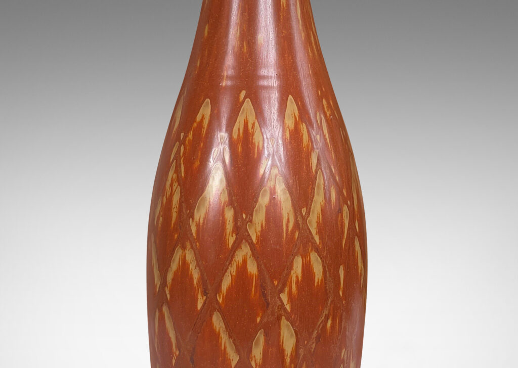 Gallery BAC tall bottle forms with carved diamond pattern, and glazed in terra-cotta/tan