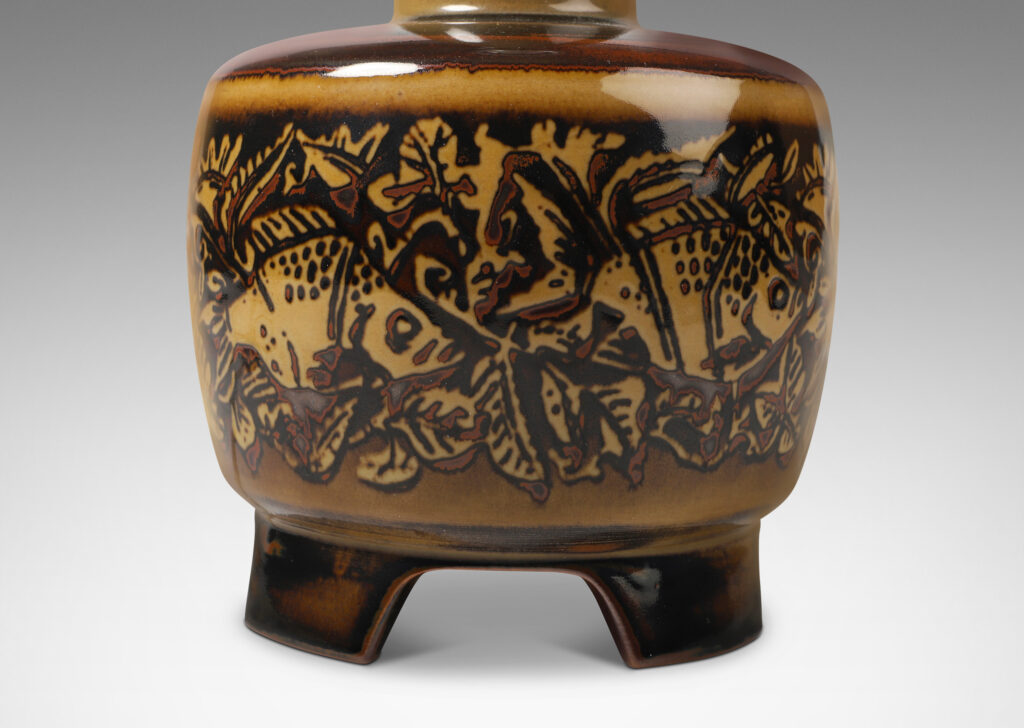 Gallery BAC drum form with legs and a tall neck, in a tan brown with dark brown shading and goldfish design