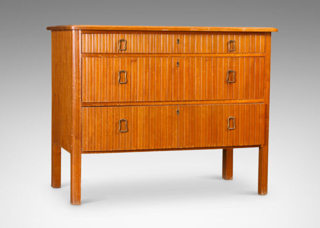 Gallery BAC three drawers with relief vertical ridges covering sides and legs, and organically modeled pulls; mahogany and brass