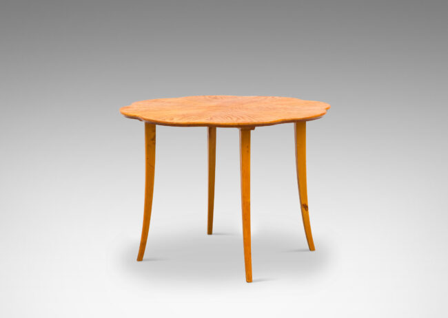 Gallery BAC ound top with lobed edge and radiating book-matched solid cuts and flared legs