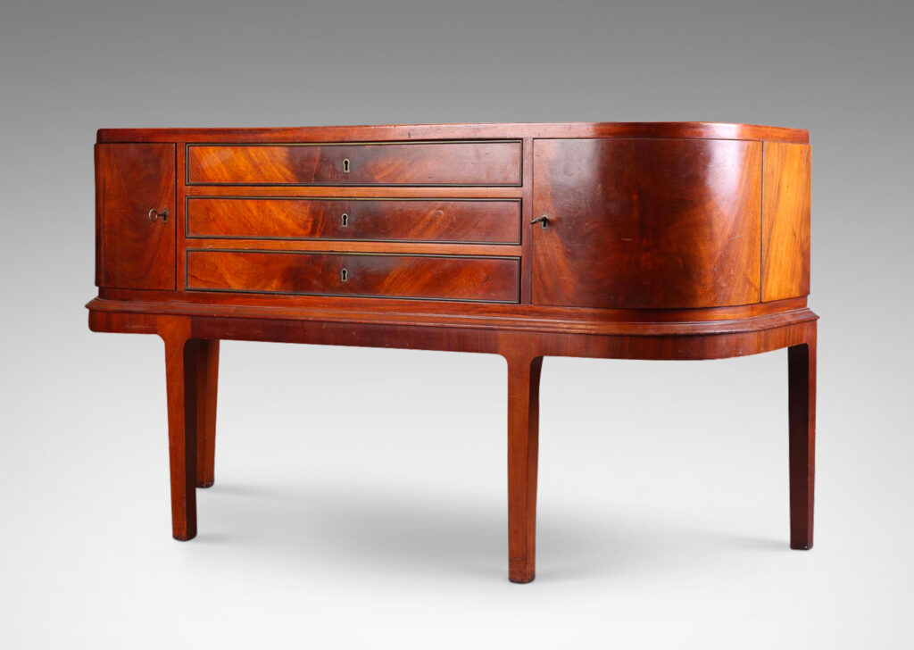 Gallery BAC hree drawers and rounded corner cabinets, on an articulated base with tapered legs; mahogany,