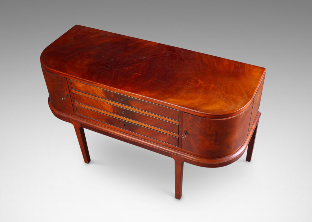 Gallery BAC hree drawers and rounded corner cabinets, on an articulated base with tapered legs; mahogany,