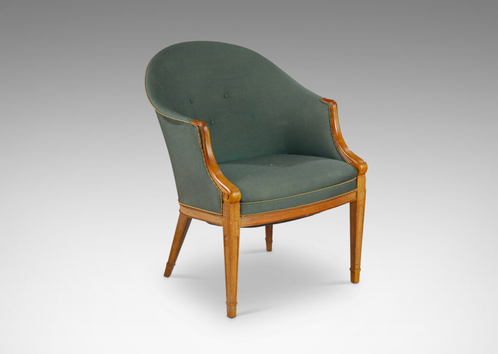 Gallery BAC curved upholstered back, with carved scroll front arms, tapered and paneled front legs and angled back legs