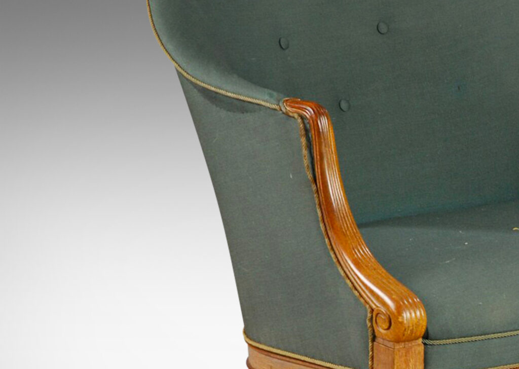 Gallery BAC curved upholstered back, with carved scroll front arms, tapered and paneled front legs and angled back legs