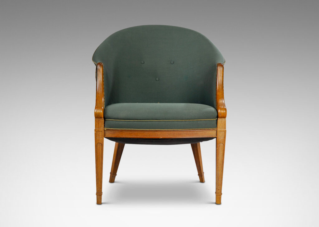 Gallery BAC curved upholstered back, with carved scroll front arms, tapered and paneled front legs and angled back legs