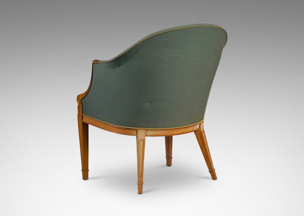 Gallery BAC curved upholstered back, with carved scroll front arms, tapered and paneled front legs and angled back legs