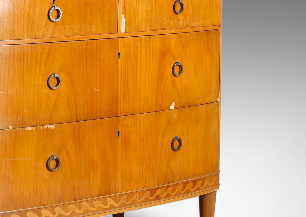 Gallery BAC four drawers, with tapered feet, ring pulls, and an ornamental inlaid band with a wave design