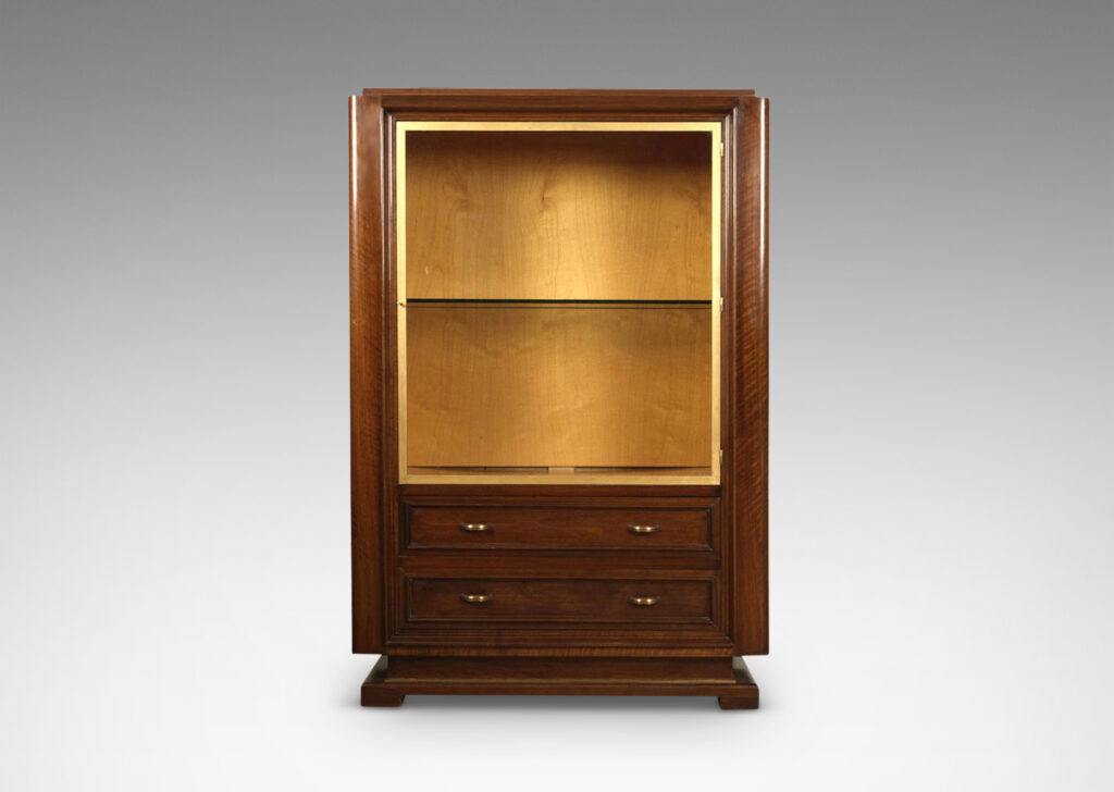 Gallery BAC sculpturally modeled case with display cabinet lined in light wood, with glass door and shelves, over two drawers