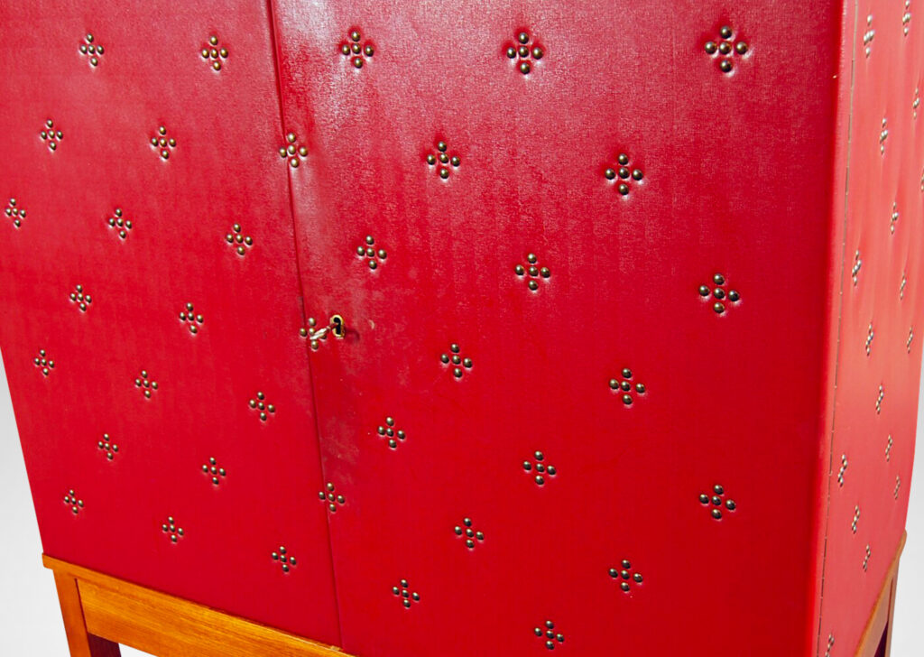 Gallery BAC two-door cupboard with shelves and three small drawers inside, covered in red leather tufted with diamond-form clusters of nail heads