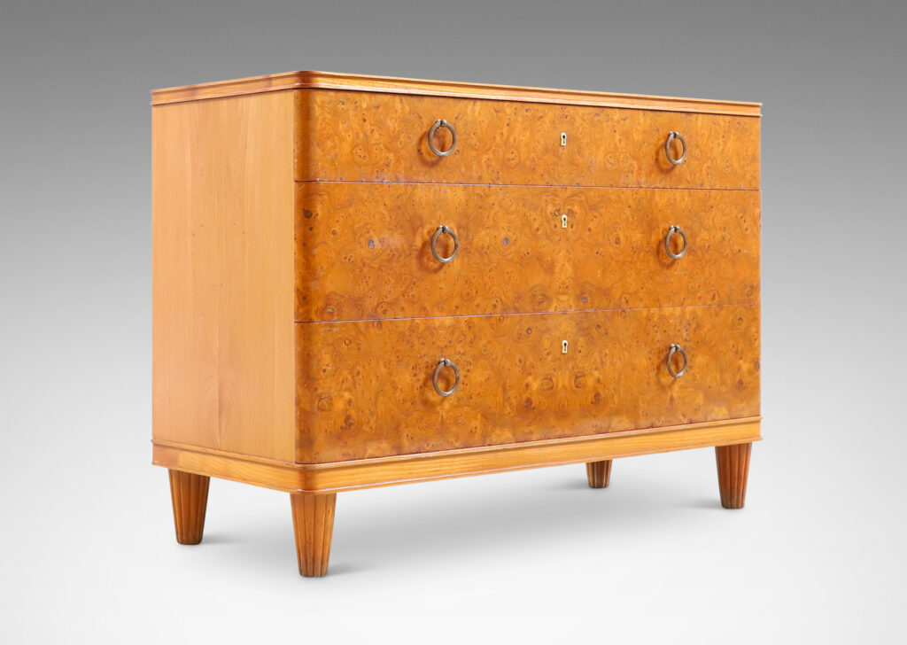 Gallery BAC three drawers veneered in burl with ring pulls, profiled top and bottom frame, and tapered legs; elm, burl and brass