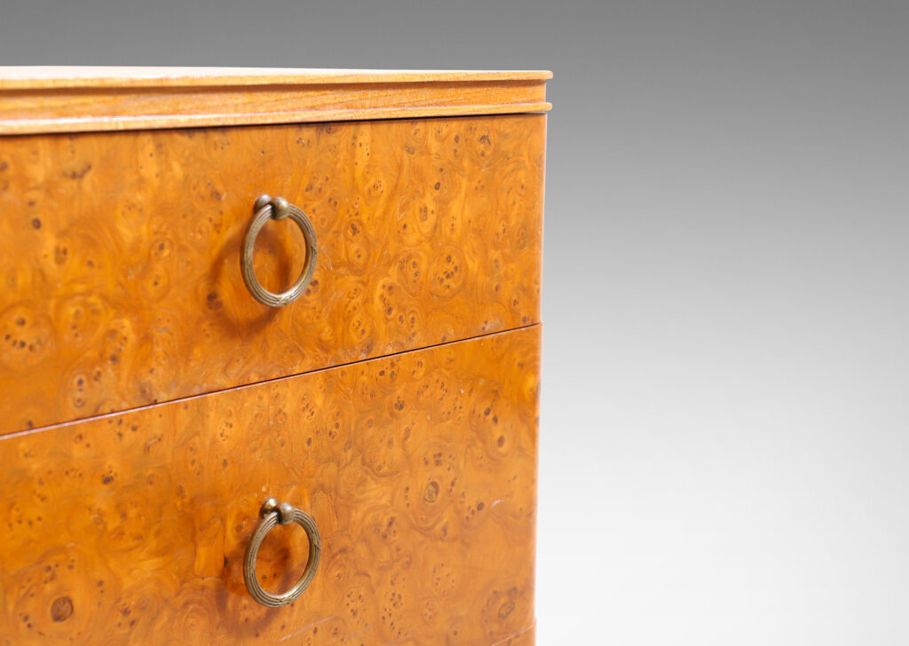 Gallery BAC three drawers veneered in burl with ring pulls, profiled top and bottom frame, and tapered legs; elm, burl and brass