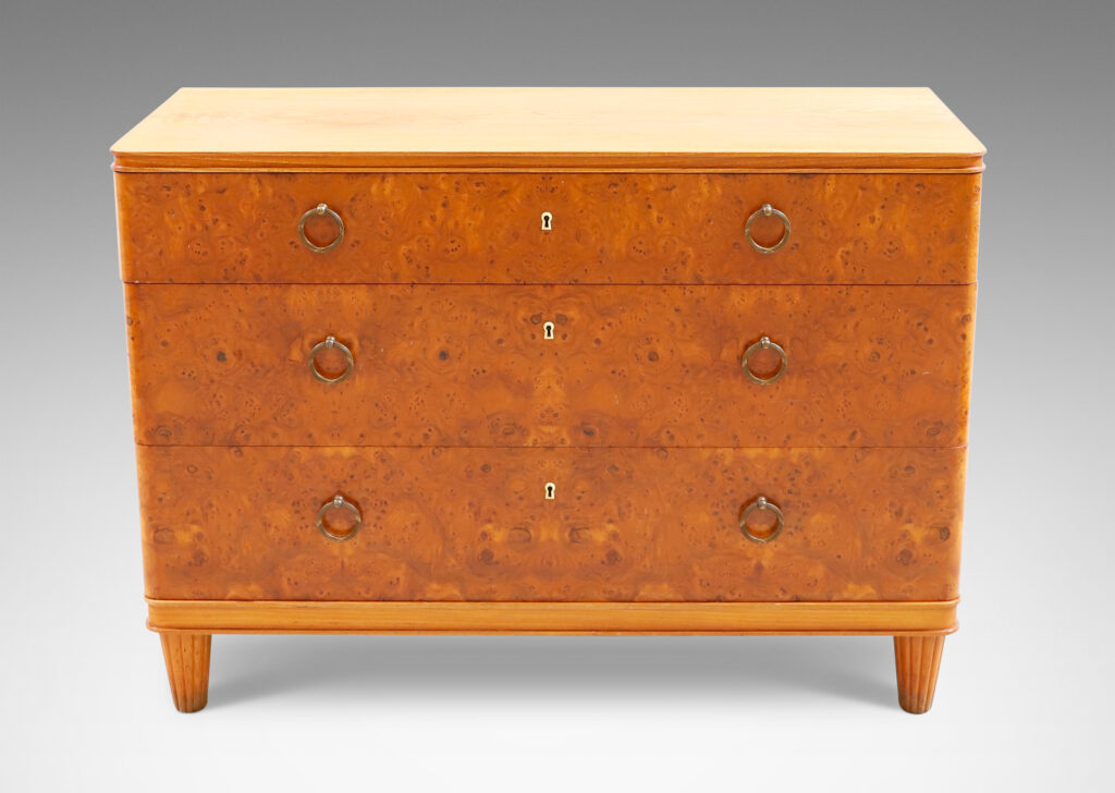 Gallery BAC three drawers veneered in burl with ring pulls, profiled top and bottom frame, and tapered legs; elm, burl and brass