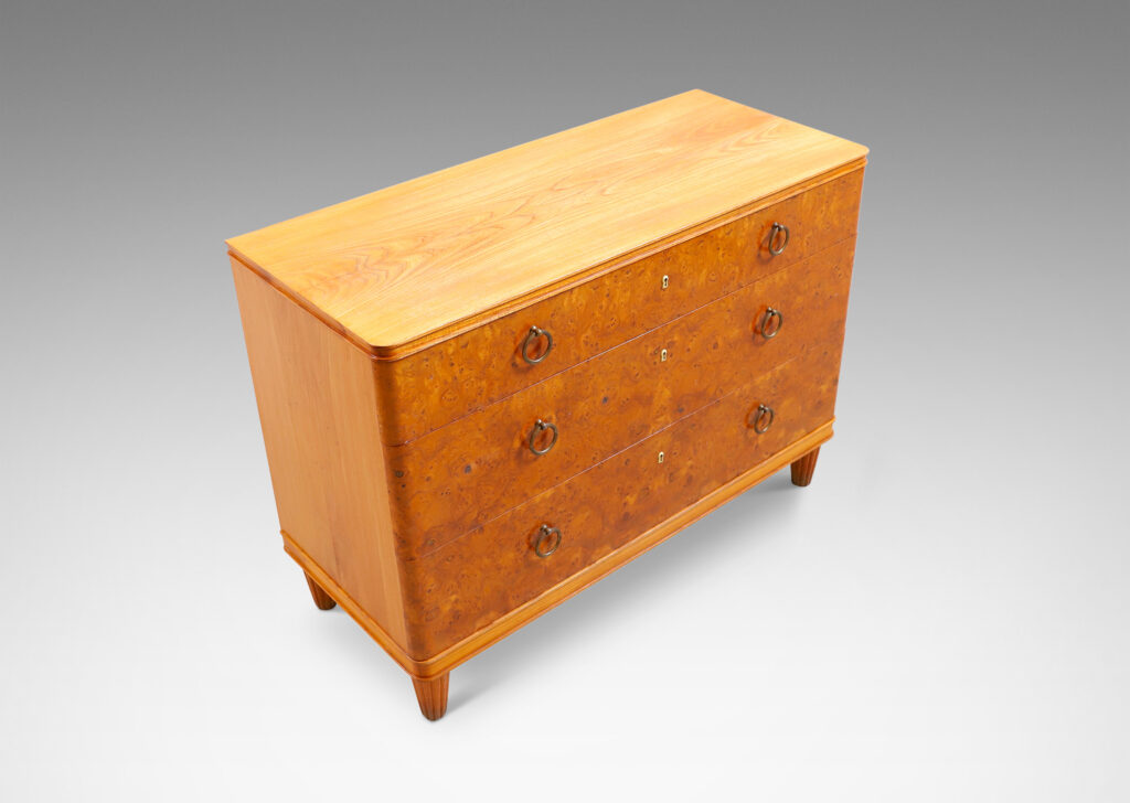 Gallery BAC three drawers veneered in burl with ring pulls, profiled top and bottom frame, and tapered legs; elm, burl and brass