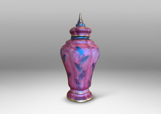 Gallery BAC lobed tapered form with flower-form finial, glazed in a sponged raspberry red luster, with purple and gilded accents;