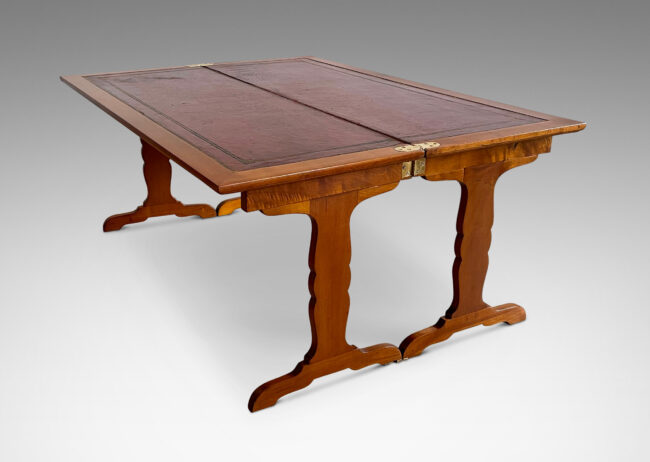 Gallery BAC “tric-trac” folding mechanism that doubles the table’s size, with cut-out style legs in the Regency taste and original leather insets