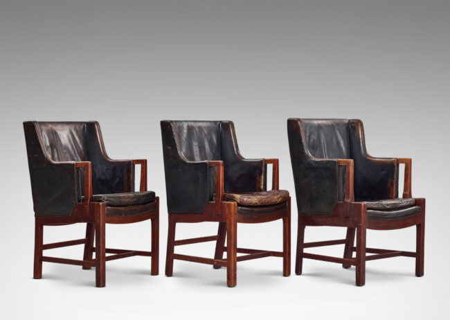 Gallery BAC arcing backs and three-quarter arms upholstered in leather, with organically modeled exposed arm fronts and legs