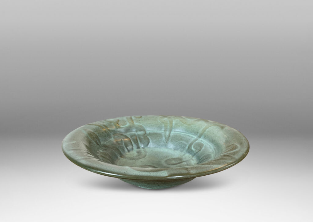 Gallery BAC concentrically lobed form with relief ornaments in gray-green glaze; earthenware