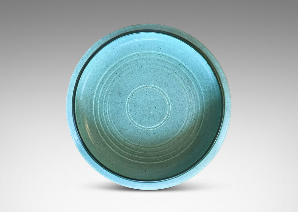 Gallery BAC modeled curved sides and carved concentric circle pattern, glazed in a soft turquoise tone with speckling and outline to rim