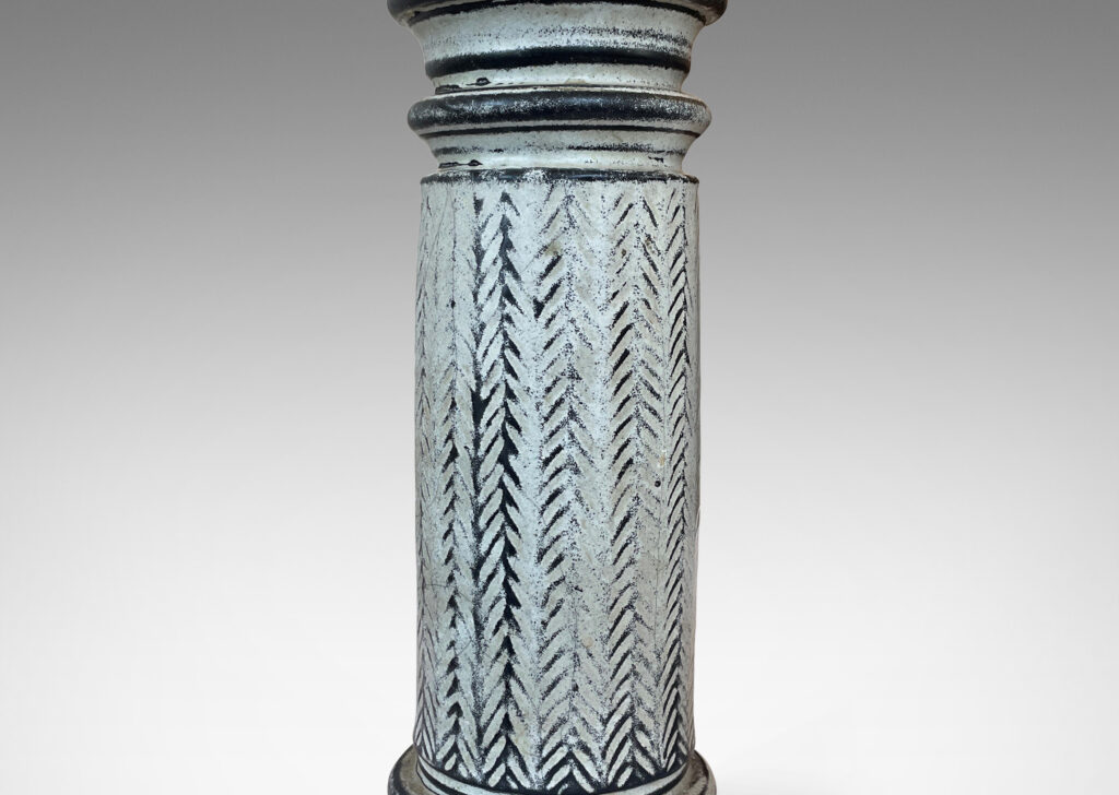 Gallery BAC column forms with sculpted capitals and bases and vertical stripes of carved herringbone