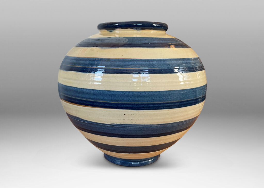 Gallery BAC wide tapering globe form, with beaded lip and plinth base, glazed with horizontal two-tone blue and ivory bands