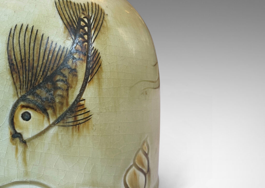 Gallery BAC gumdrop half-round form, carved with charming fish reliefs, glazed in a pale yellow with touches of brown