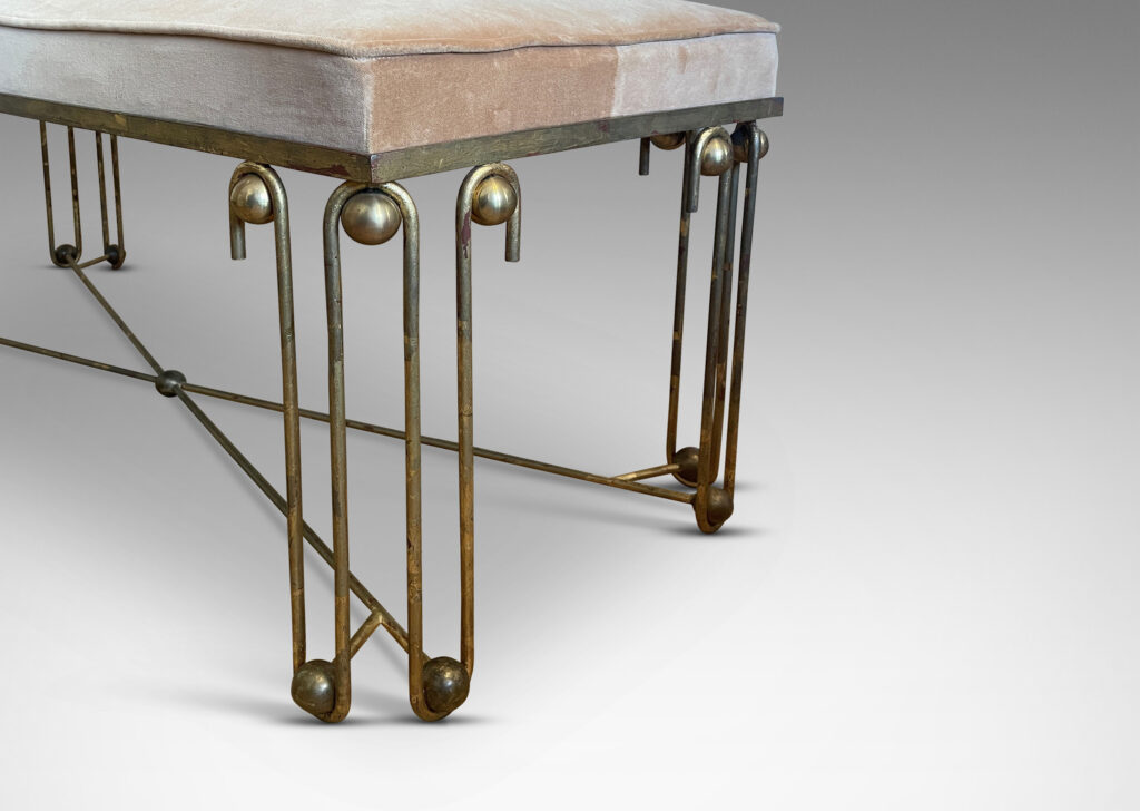 Gallery BAC legs comprised of undulating line motifs, joined by cross stretchers, ornamented with “boules”; gilded iron, brass