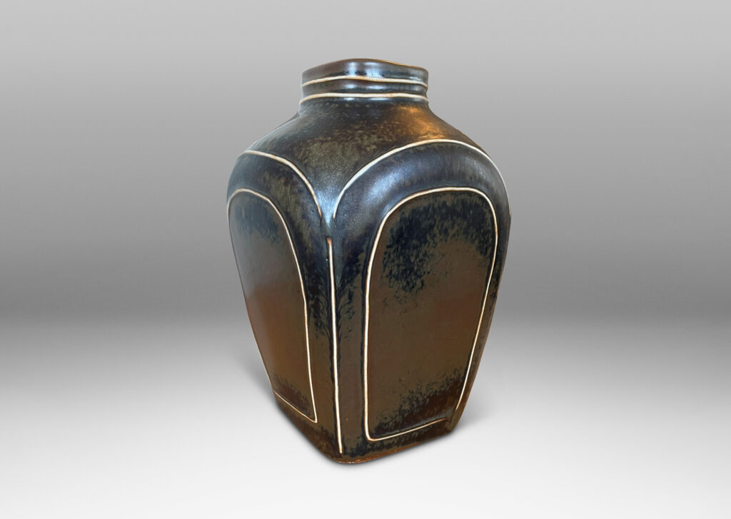 Gallery BAC four arched sides with squinched shoulders and a bottle mouth, glazed in a deep brown