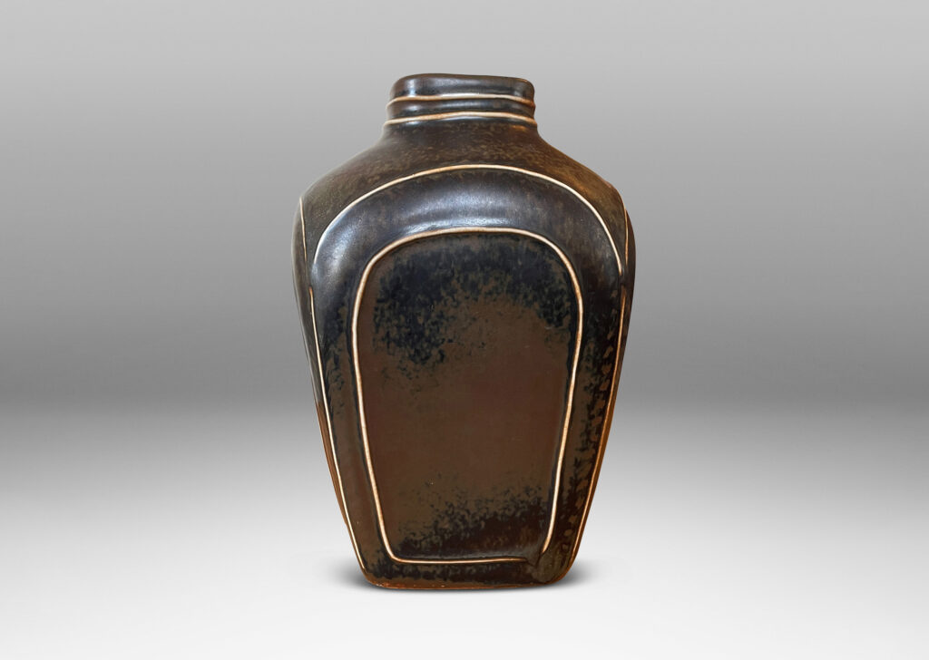 Gallery BAC four arched sides with squinched shoulders and a bottle mouth, glazed in a deep brown