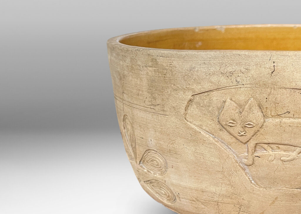 Gallery BAC straight sides decorated with carved animal motifs and stylized flora, and a gloss golden interior glaze