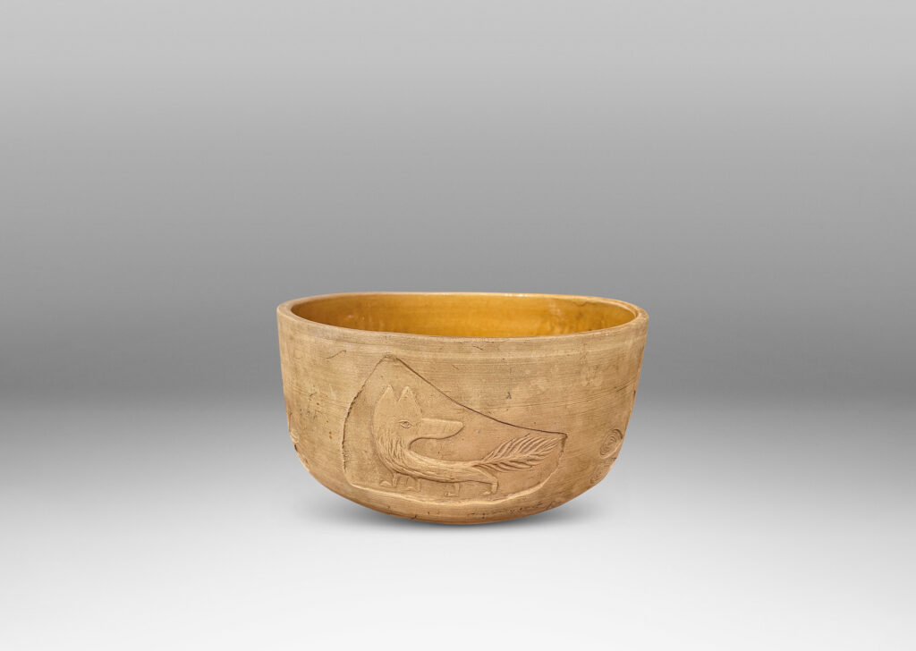 Gallery BAC straight sides decorated with carved animal motifs and stylized flora, and a gloss golden interior glaze