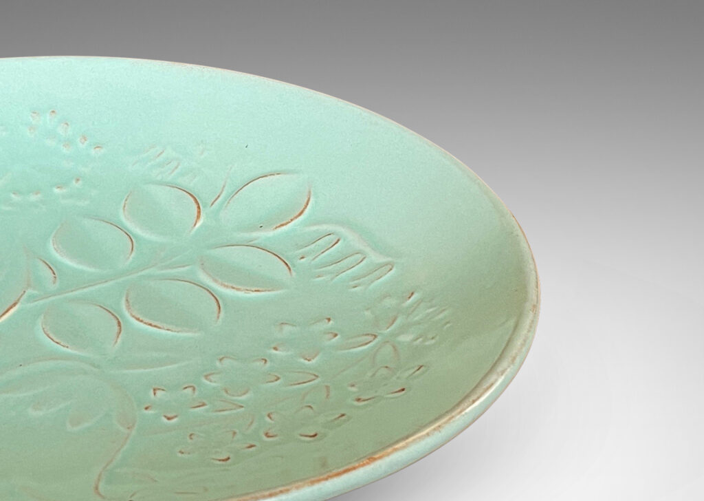 Gallery BAC smoothly modeled concave form with relief floral design inside, glazed in a muted celadon green