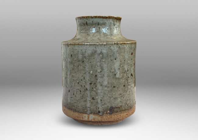 Gallery BAC cylindrical form with reveal base and coved neck with wide mouth, glazed in light green-gray with punctuated with brown speckles