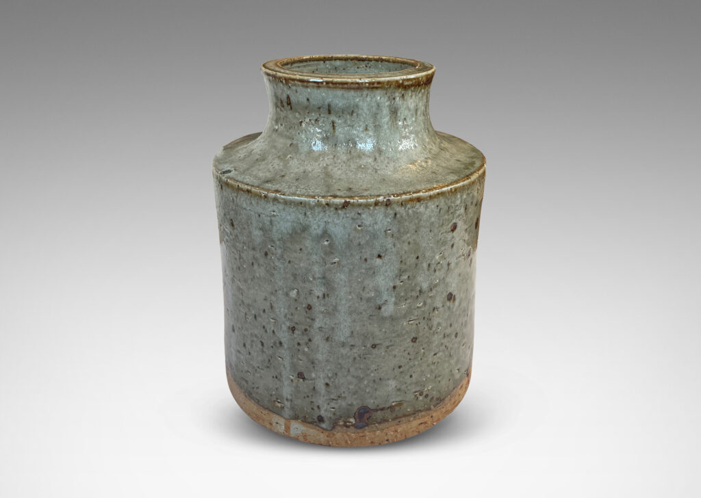 Gallery BAC cylindrical form with reveal base and coved neck with wide mouth, glazed in light green-gray with punctuated with brown speckles