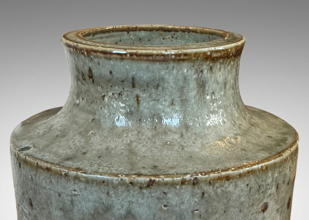 Gallery BAC cylindrical form with reveal base and coved neck with wide mouth, glazed in light green-gray with punctuated with brown speckles