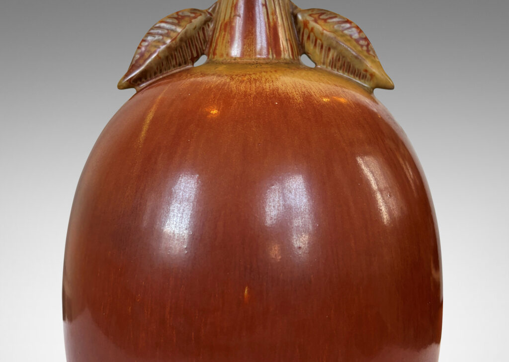 Gallery BAC ovoid form with stem-like neck with leaves, glazed in burnt sienna with tan accents