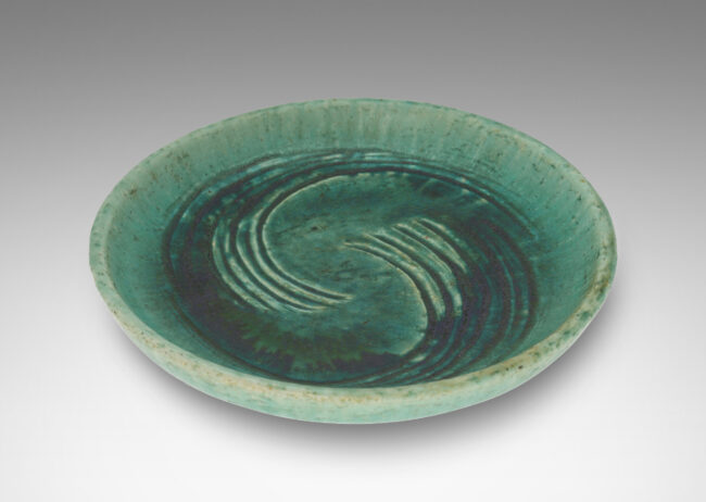 Gallery BAC flat bottom with carved swirling motifs and angled sides, with a thin turquoise glaze