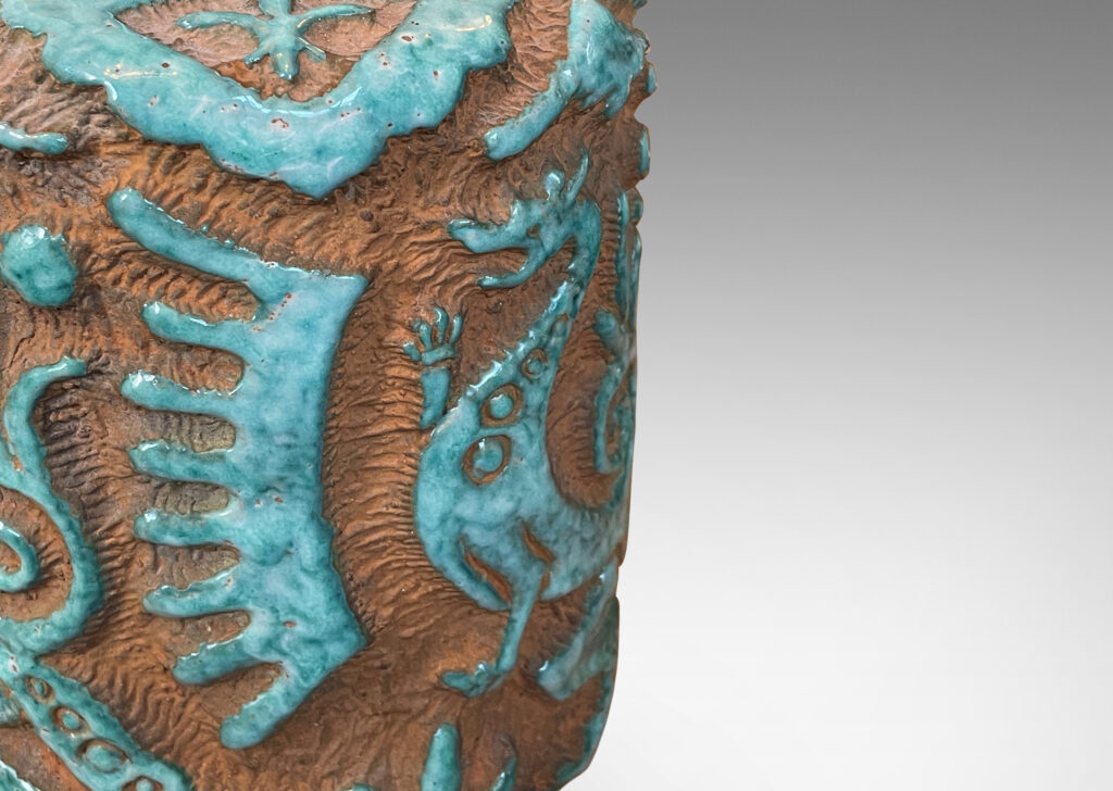 Gallery BAC cylindrical "albarello" form encircled with carved dragons and exotic motifs, partially glazed in a pale jade green, with matte terra cotta background