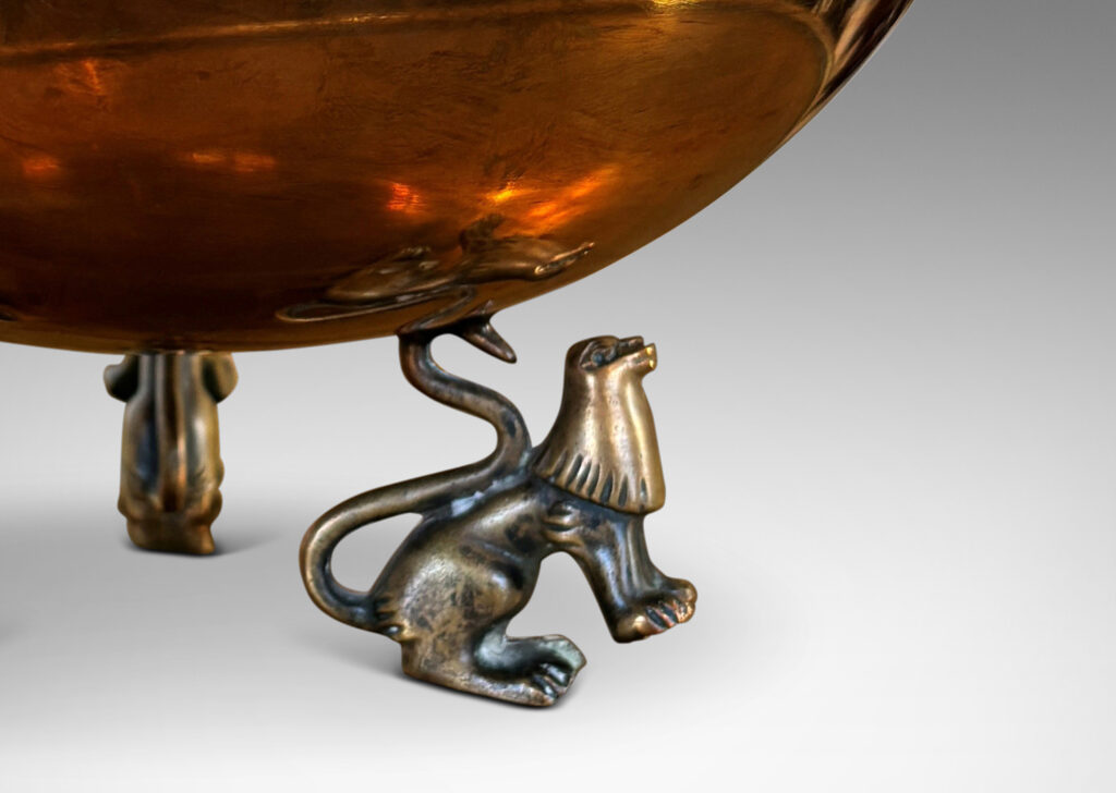 Gallery BAC hemisphere form with engraved pinstripes near rim, supported by the springing tails of three lions; bronze