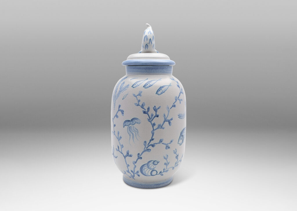 Gallery BAC tall ovoid form with fish form finial, glazed in a craquel white, surrounded with charming hand-painted pictures of marine flora and fauna in blue