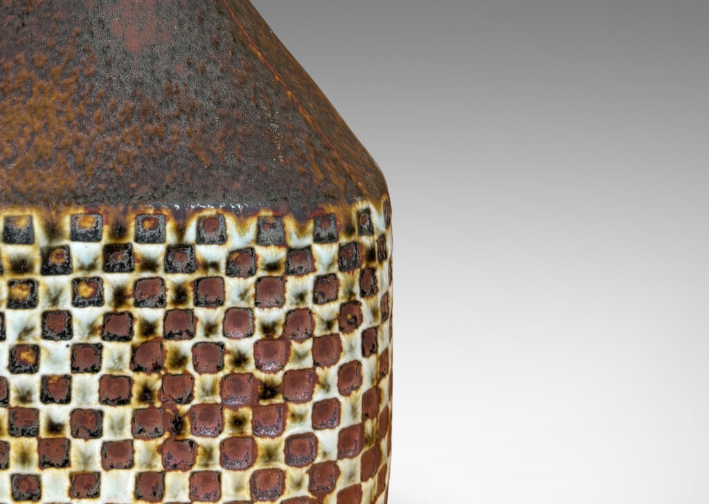 Gallery BAC square bottle-like form with checker relifs and sprouting neck, glazed in pale gray and oxblood-black