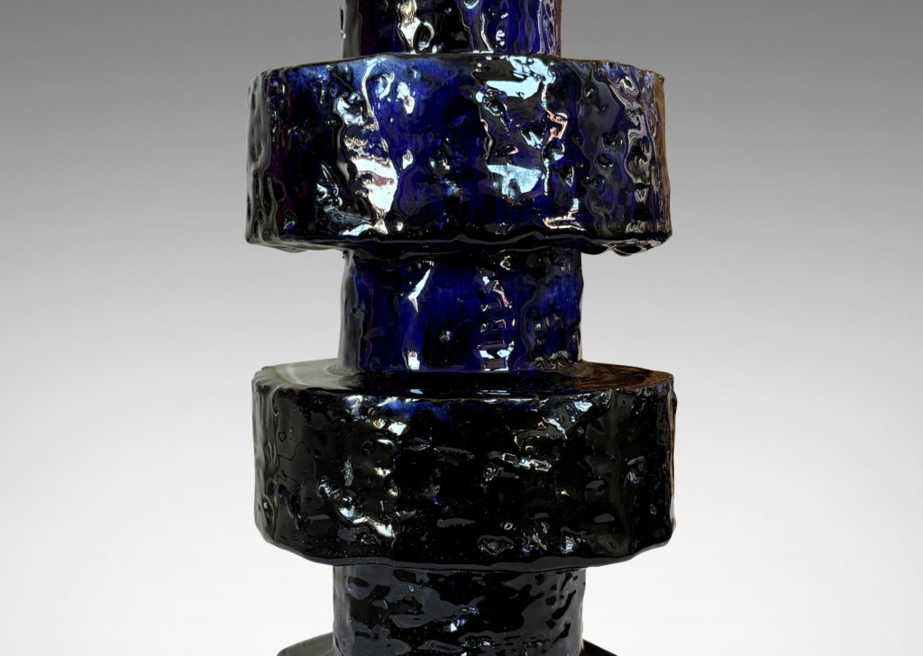 Gallery BAC coined stack of cylindrical forms in textured grog, with a deep flowing gloss blue glaze