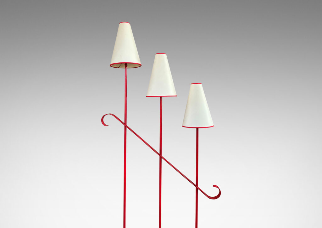 Gallery BAC three tiered stands topped with lights, joined by a scrolled brace and mounted on a cross form base with scroll feet, painted red